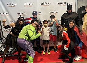 children with superheros at the movie